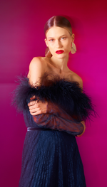 Vestido em renda, saia plissada e decote com plumas