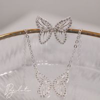 Foto do produto CONJUNTO BRINCO + COLAR BORBOLETA BANHADO EM PRATA 925