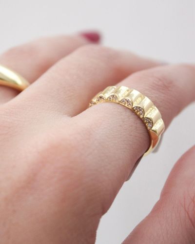 Anel dourado cravejado com textura ondulada  