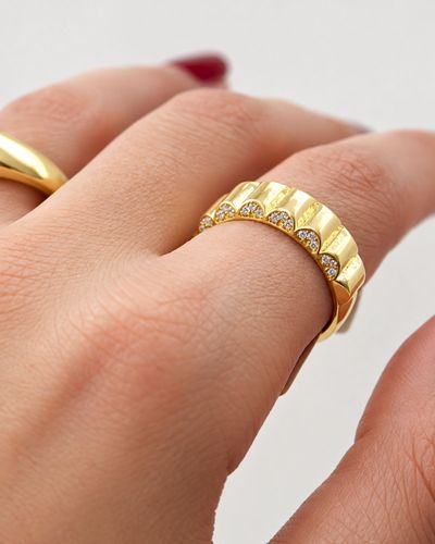 Anel dourado cravejado com textura ondulada  